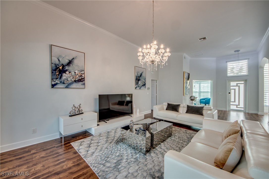 2703 Southwest 43rd Terrace Cape Coral, FL 33914 - Photo 7 of 50 a living room with furniture and a chandelier