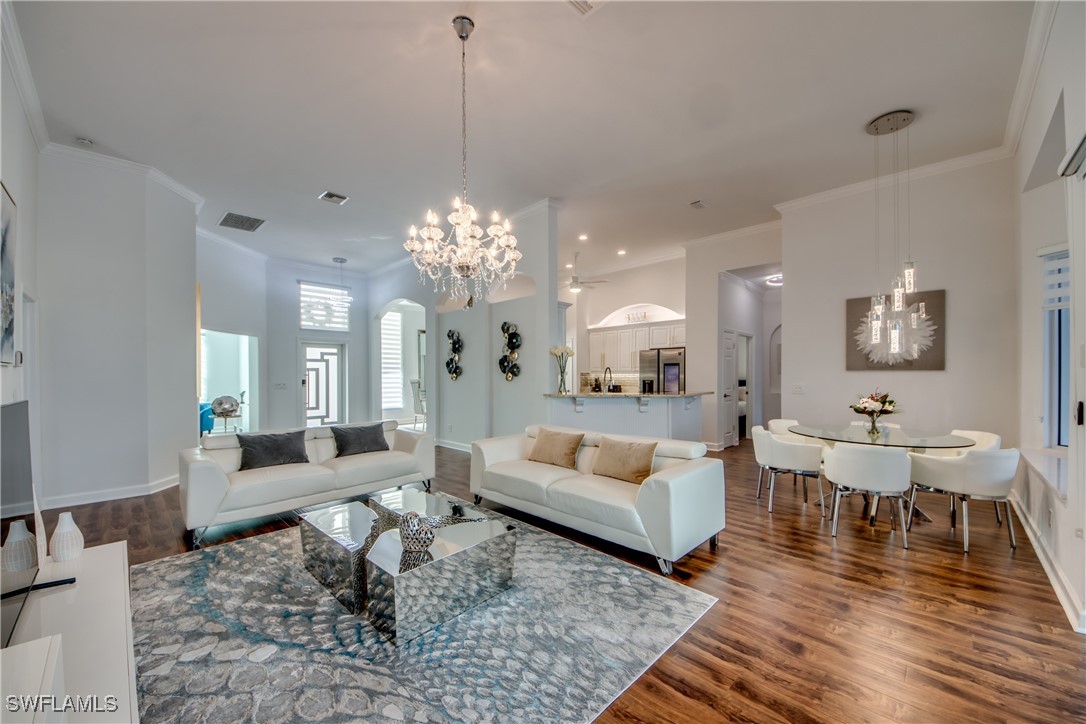 2703 Southwest 43rd Terrace Cape Coral, FL 33914 - Photo 8 of 50 a living room with couches and a dining table with wooden floor