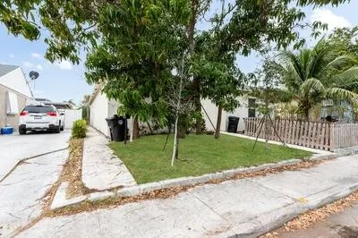 a view of a street with a house and a large tree