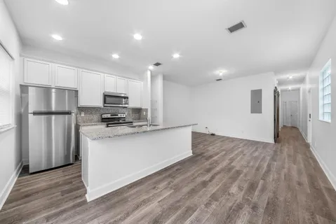 a kitchen with stainless steel appliances granite countertop a refrigerator a stove a sink and a granite counter tops