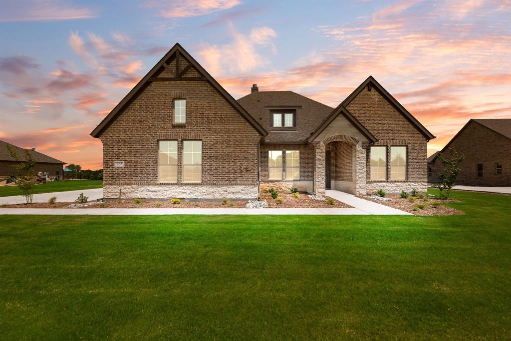 a front view of a house with yard and green space