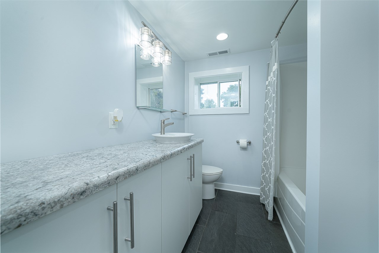 8424 South Main Street Rochelle, IL 61068 - Photo 17 of 26 a bathroom with a granite countertop sink a toilet and a mirror