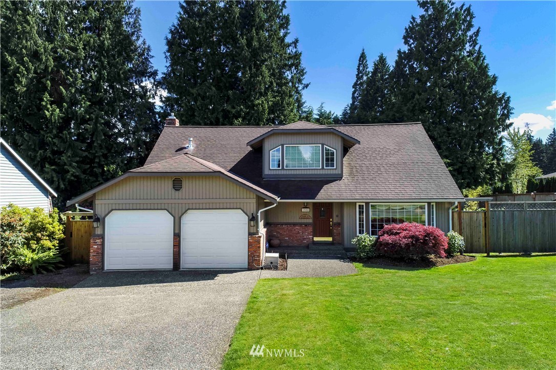 1508 243rd Place Southeast Bothell, WA 98021 - Photo 2 of 32 a front view of a house with a garden and trees