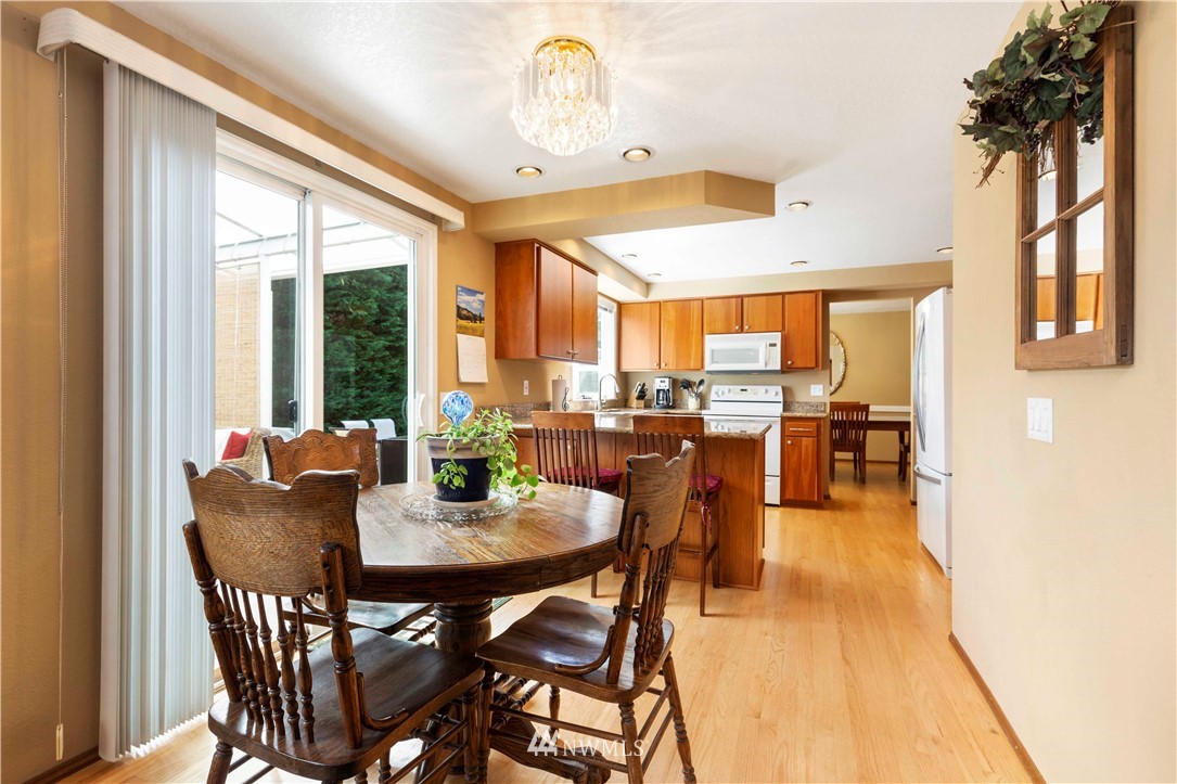 1508 243rd Place Southeast Bothell, WA 98021 - Photo 15 of 32 a dining room with furniture a chandelier and wooden floor