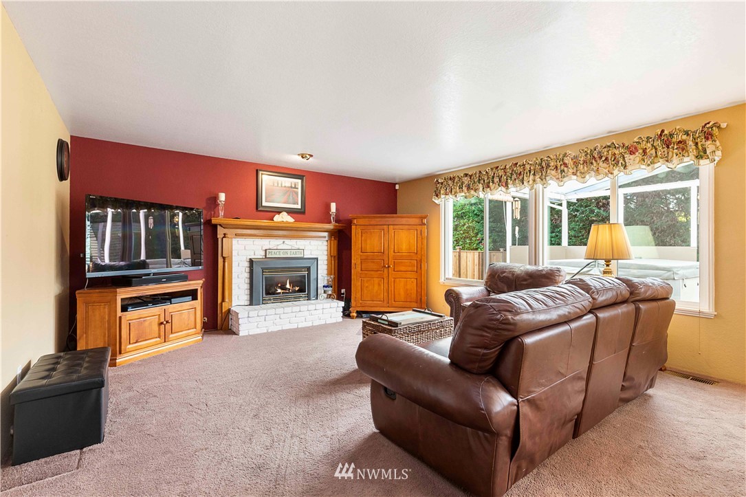 1508 243rd Place Southeast Bothell, WA 98021 - Photo 17 of 32 a living room with furniture a fireplace and a flat screen tv