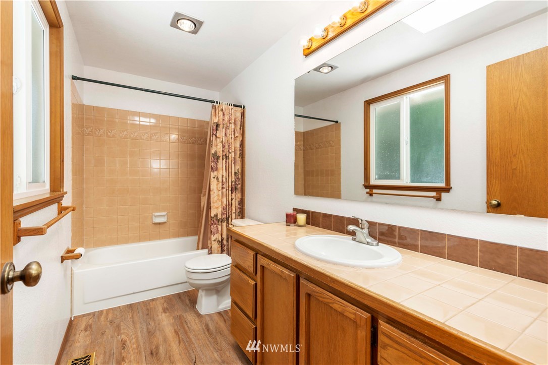 1508 243rd Place Southeast Bothell, WA 98021 - Photo 21 of 32 a bathroom with a granite countertop sink toilet and shower