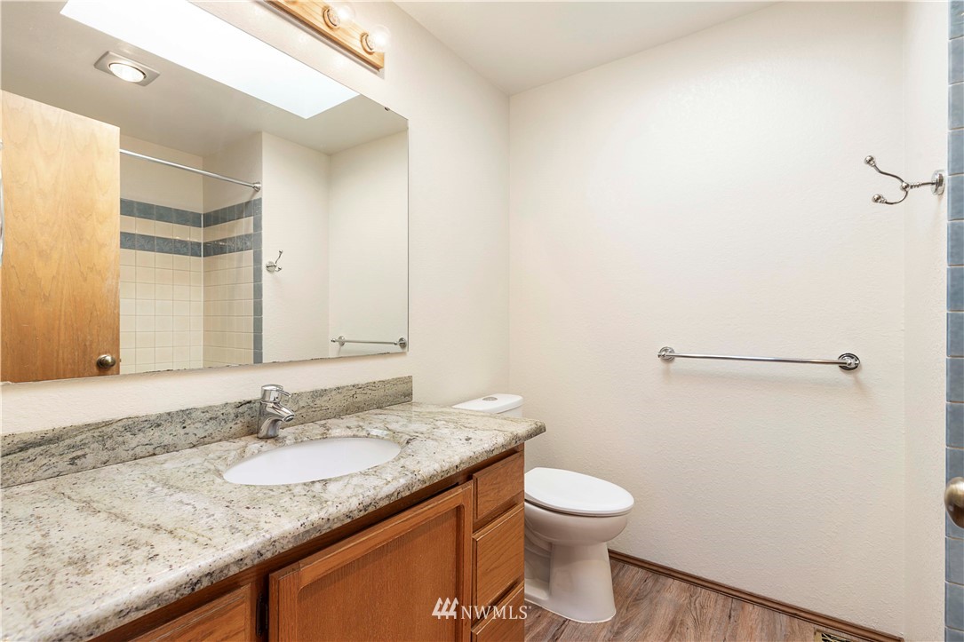 1508 243rd Place Southeast Bothell, WA 98021 - Photo 24 of 32 a bathroom with a granite countertop sink a toilet and a mirror