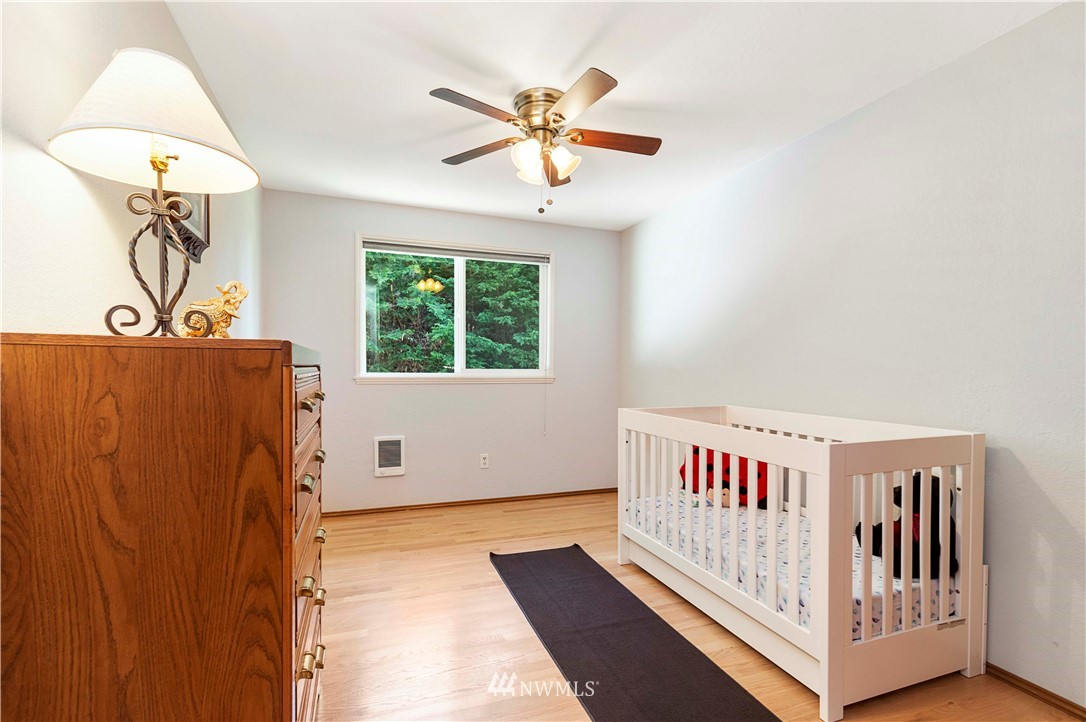 1508 243rd Place Southeast Bothell, WA 98021 - Photo 25 of 32 a view of a room with wooden floor windows and a ceiling fan