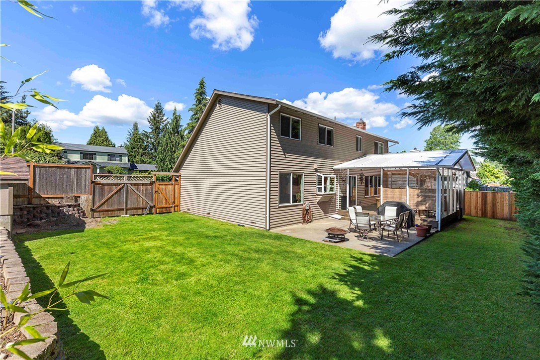 1508 243rd Place Southeast Bothell, WA 98021 - Photo 30 of 32 a view of a house with backyard sitting area and garden