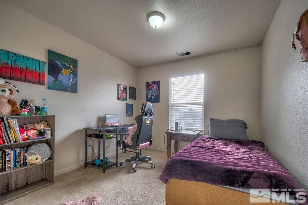 2275 Big Trail Circle Reno, NV 89521 - Photo 10 of 40 a bedroom with a bed a desk and chair with the shoe rack