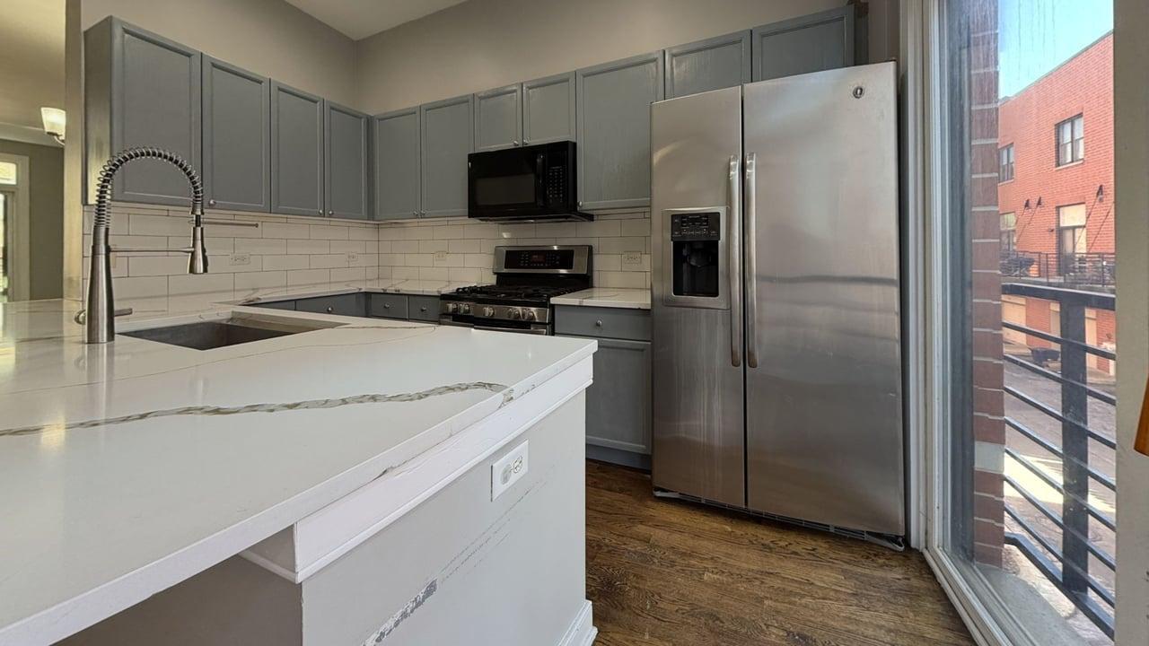 2350 West George Street, Unit 2350 Chicago, IL 60618 - Photo 8 of 21 a kitchen with a refrigerator a stove and a sink with wooden floor