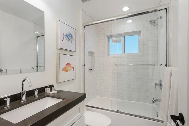 a bathroom with a granite countertop sink mirror toilet and bathtub