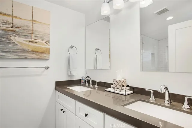 a bathroom with double sink and a mirror