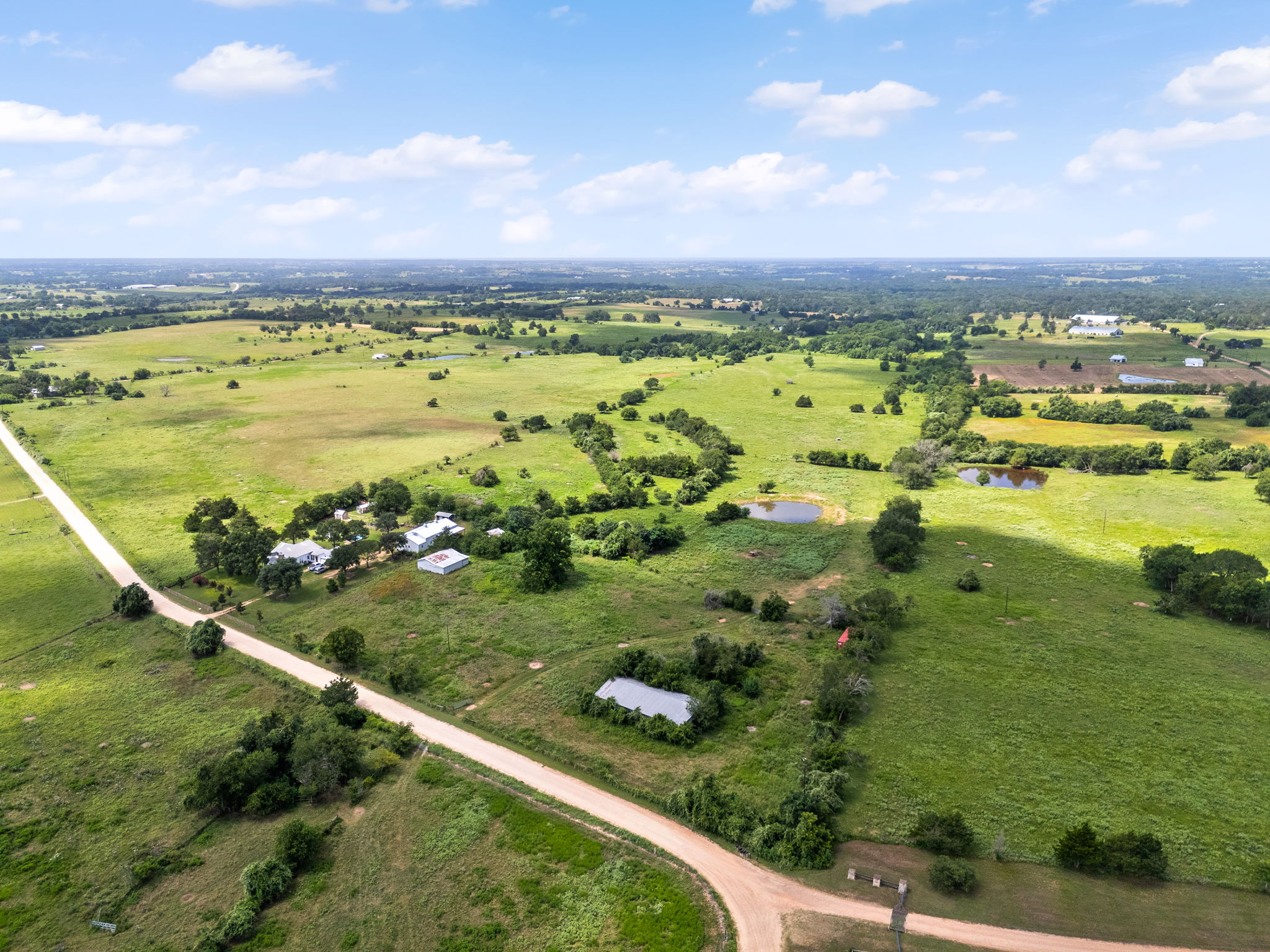 0 Thielemann Road Industry, TX 78944 - Photo 8 of 40 Sprawling acreage features a long private drive, multiple ponds, and a cluster of residences, offering serene country living.
