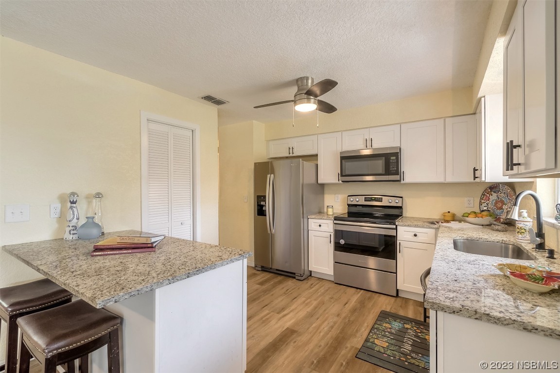 1851 Lime Tree Drive Edgewater, FL 32141 - Photo 9 of 25 a kitchen with stainless steel appliances granite countertop a sink stove microwave and refrigerator