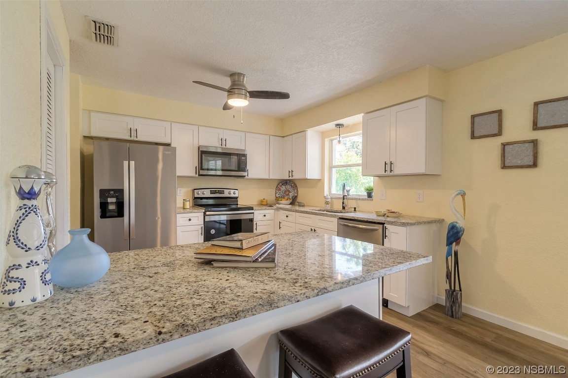 1851 Lime Tree Drive Edgewater, FL 32141 - Photo 10 of 25 a kitchen with stainless steel appliances granite countertop a sink a stove and refrigerator