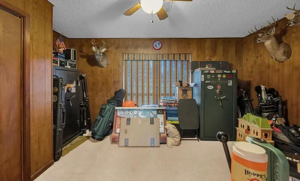 a bedroom with furniture a flat screen tv and a window