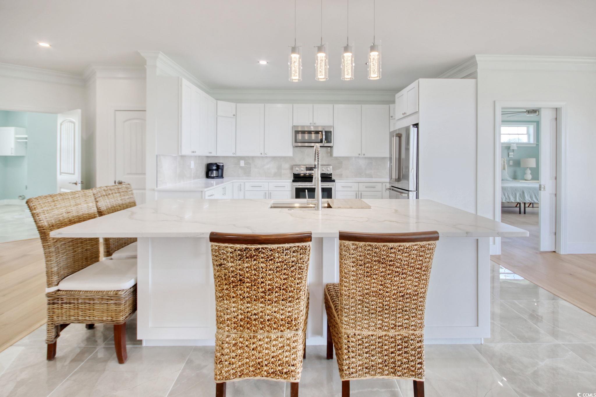 125 Oak Bay Drive Georgetown, SC 29440 - Photo 13 of 39 Kitchen with appliances with stainless steel finishes, ornamental molding, white cabinets, decorative backsplash, and light stone counters