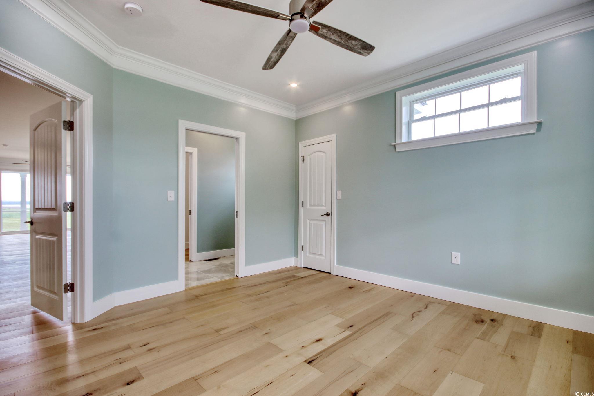 125 Oak Bay Drive Georgetown, SC 29440 - Photo 19 of 39 Unfurnished bedroom featuring crown molding, light wood-style floors, and ceiling fan