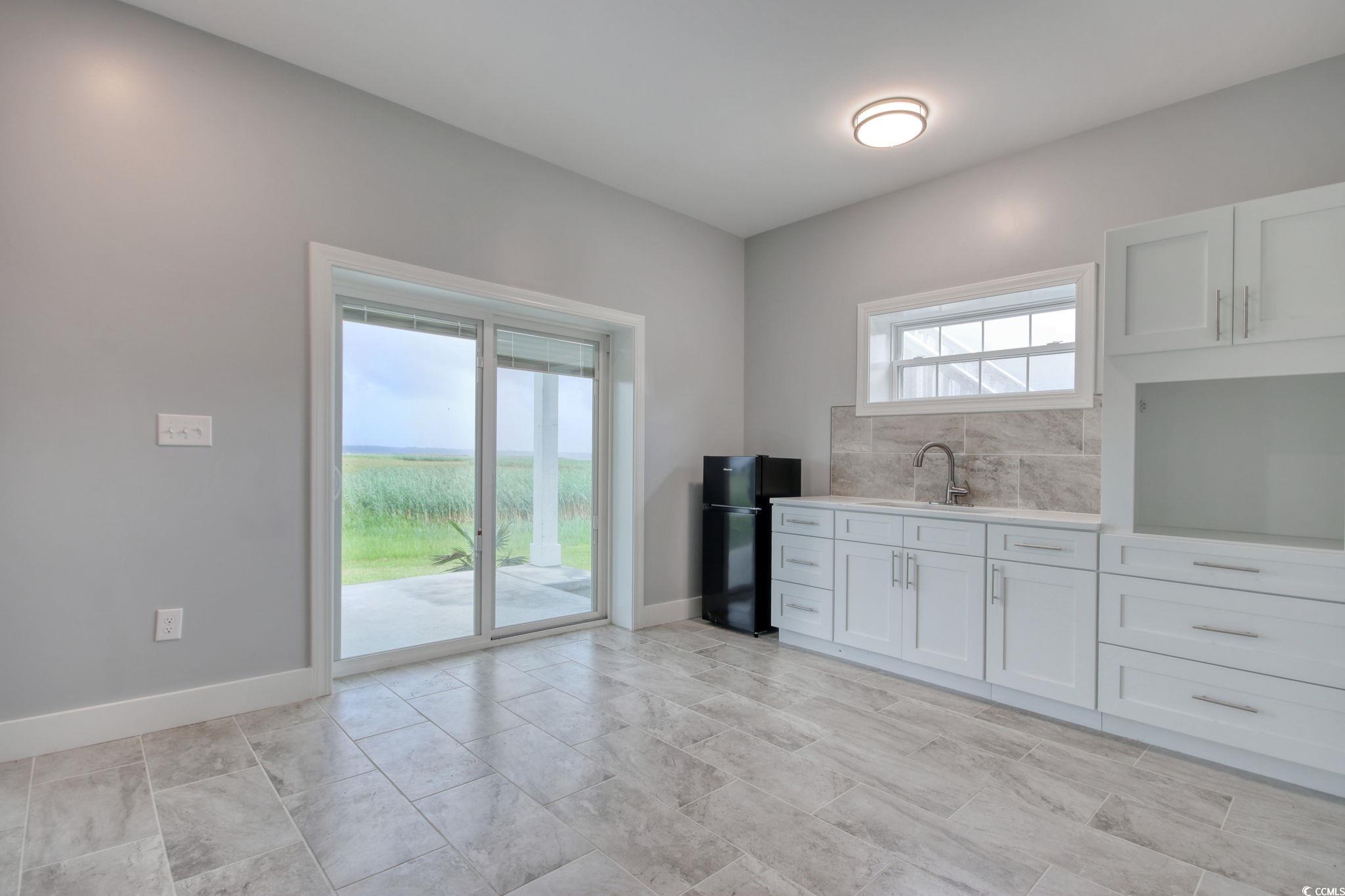 125 Oak Bay Drive Georgetown, SC 29440 - Photo 31 of 39 Kitchen with freestanding refrigerator, light countertops, and white cabinetry