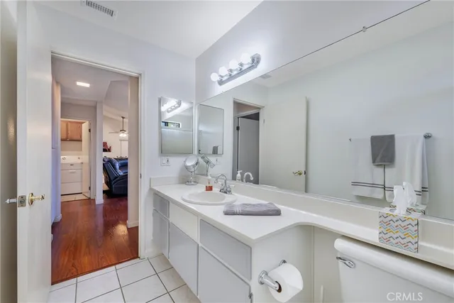 a bathroom with a sink a toilet a large mirror and shower