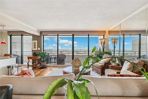 a living room with furniture and floor to ceiling windows