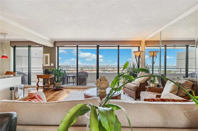 a living room with furniture and floor to ceiling windows