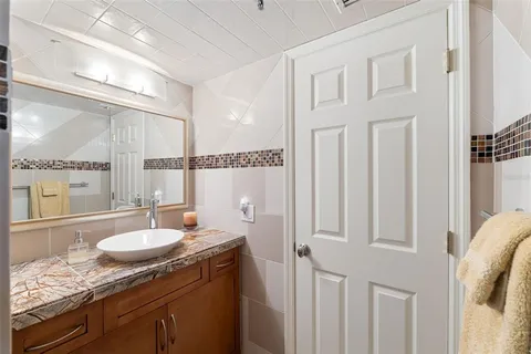 a bathroom with a granite countertop sink a mirror and shower