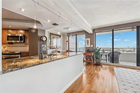 a living room with furniture large windows and wooden floor