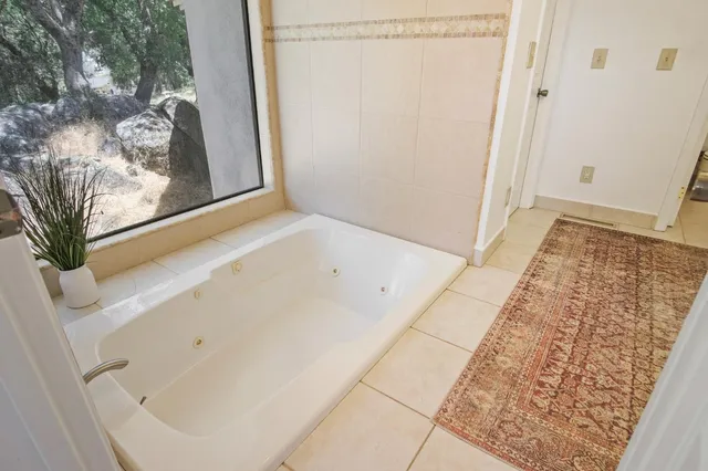 a bathroom with a tub a sink and mirror