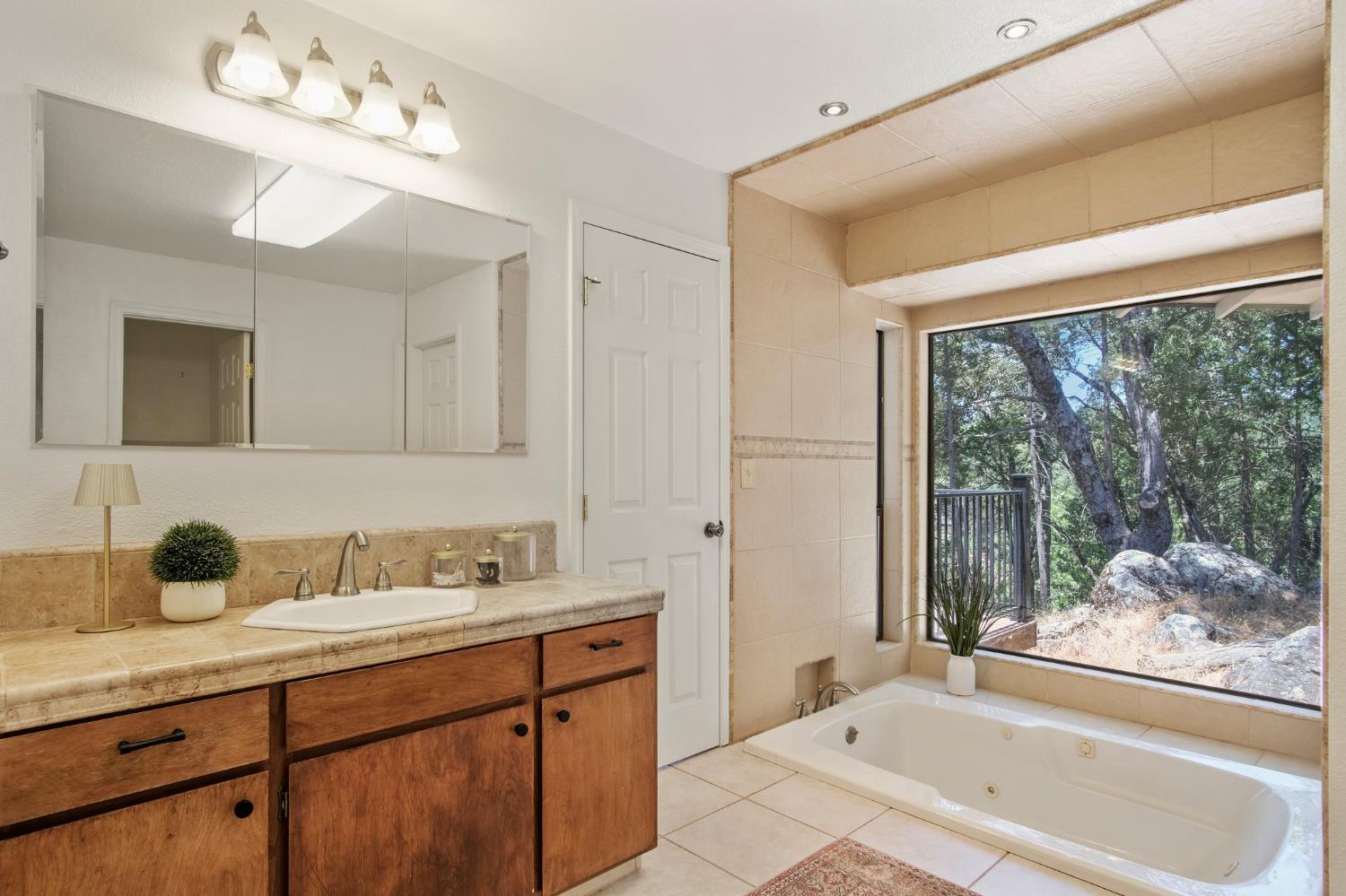 18950 Black Oak Road Sonora, CA 95370 - Photo 22 of 46 a bathroom with a tub a sink and mirror