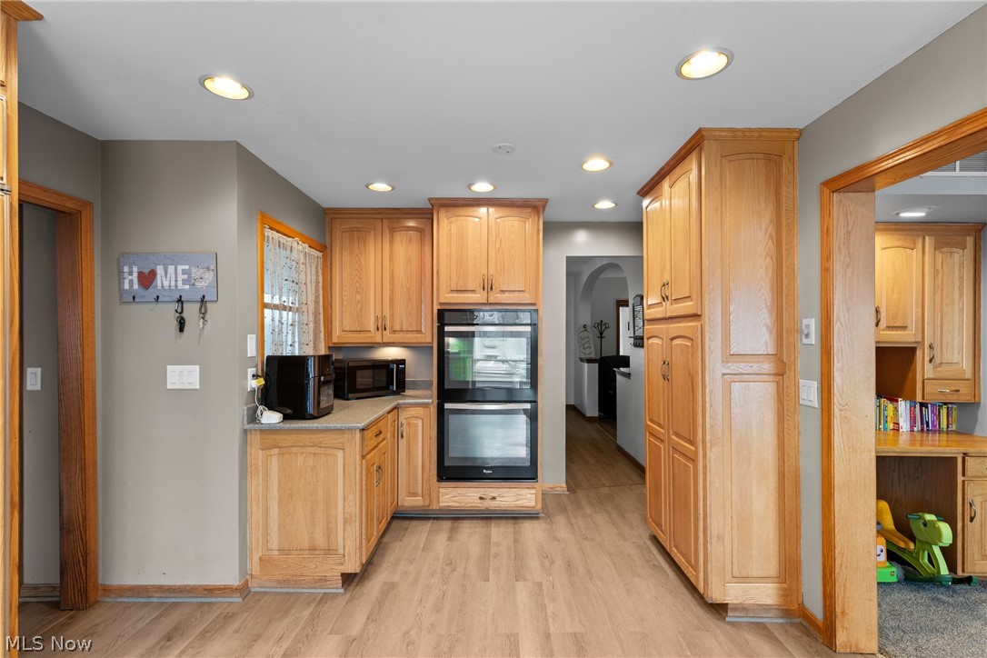 64508 Slade Road Cambridge, OH 43725 - Photo 13 of 50 Kitchen with arched walkways, black appliances, recessed lighting, light wood-type flooring, and light wood finish cabinets