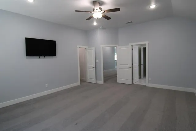 an empty room with closet and a ceiling fan