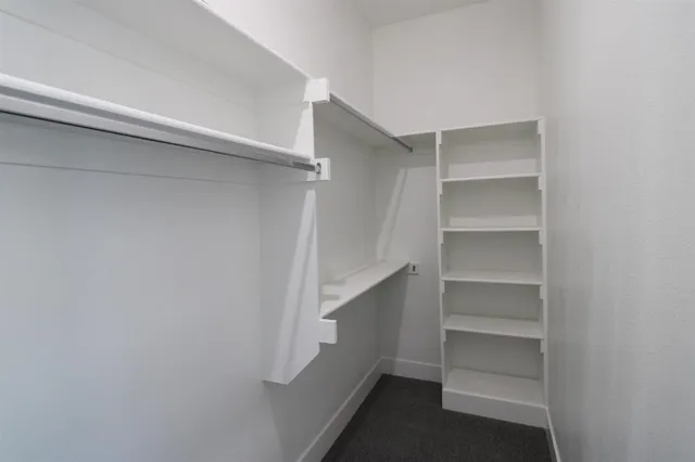 a view of walk in closet with empty racks