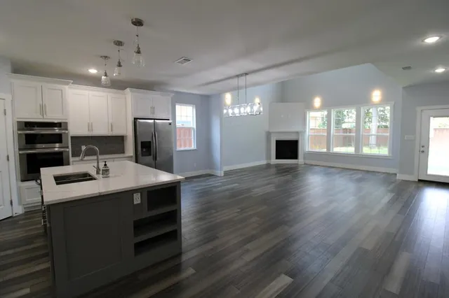 a kitchen with kitchen island a sink stainless steel appliances and cabinets
