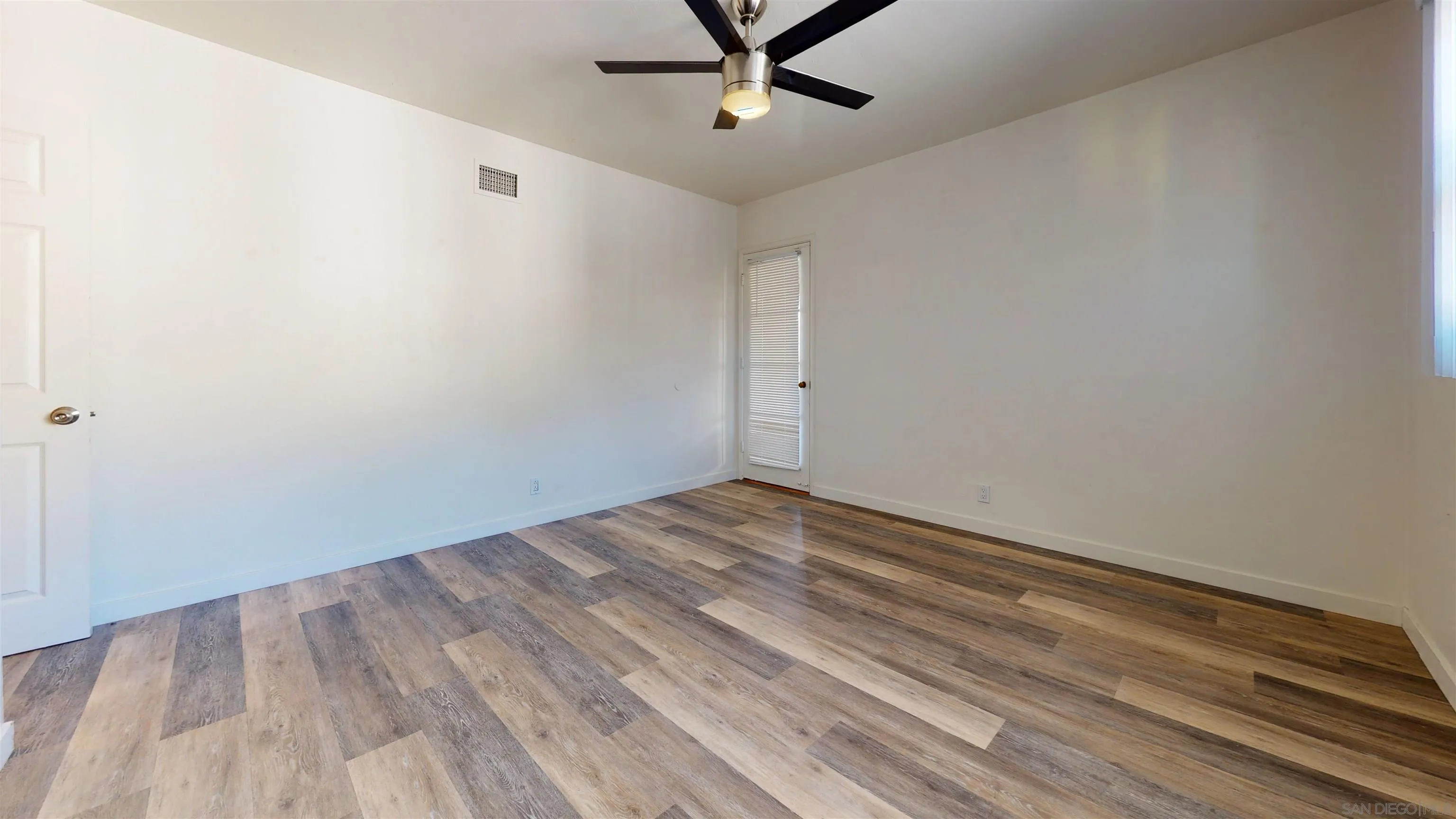 5555 Mary Ln Drive San Diego, CA 92115 - Photo 20 of 39 a view of a room with wooden floor and a ceiling fan