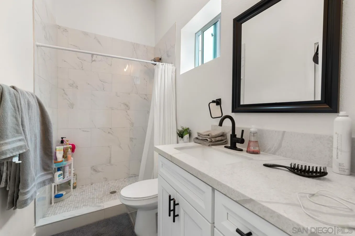 5555 Mary Ln Drive San Diego, CA 92115 - Photo 30 of 39 a bathroom with a sink a toilet and shower curtain