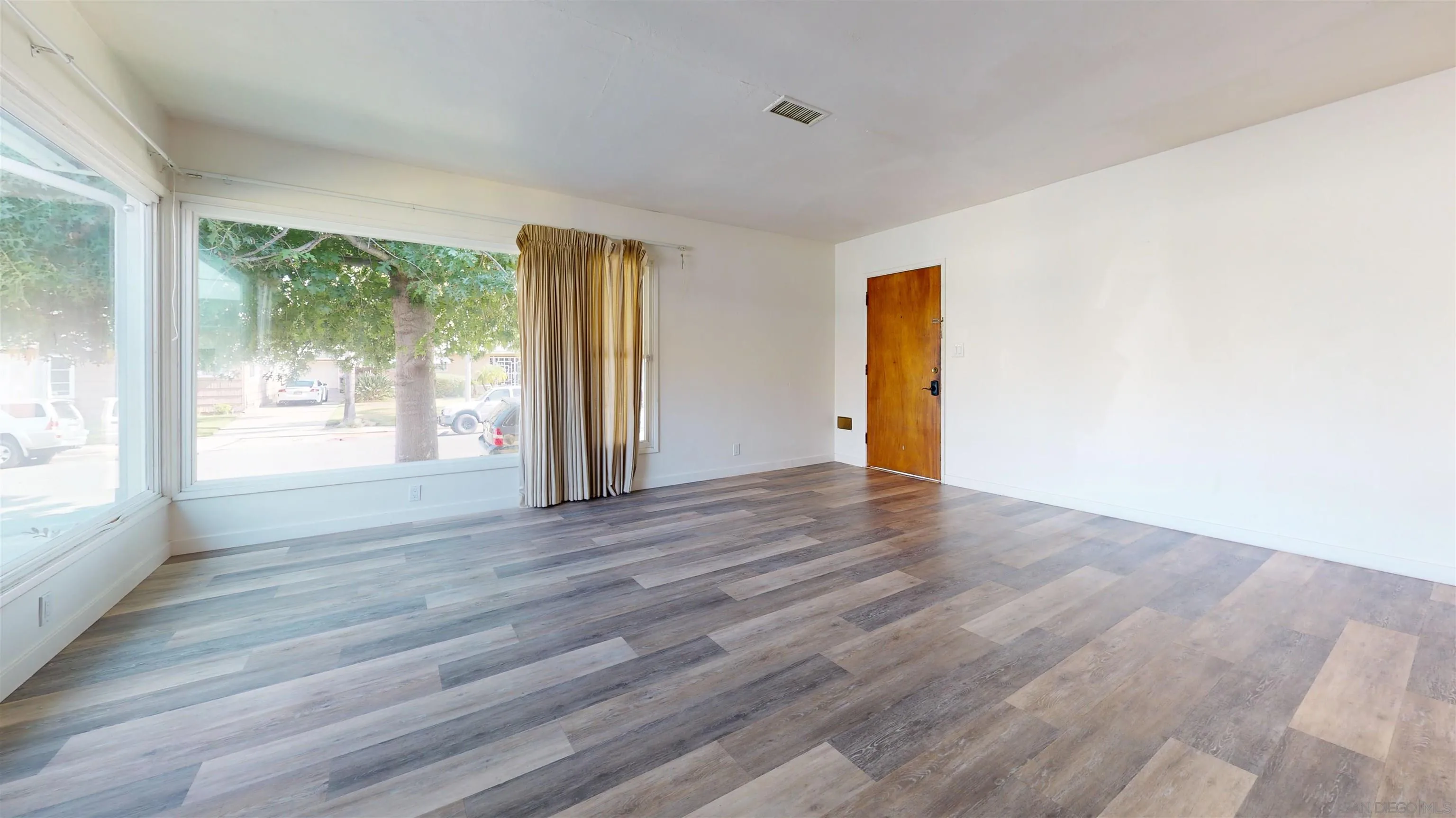 5555 Mary Ln Drive San Diego, CA 92115 - Photo 8 of 39 a view of an empty room with wooden floor and a window