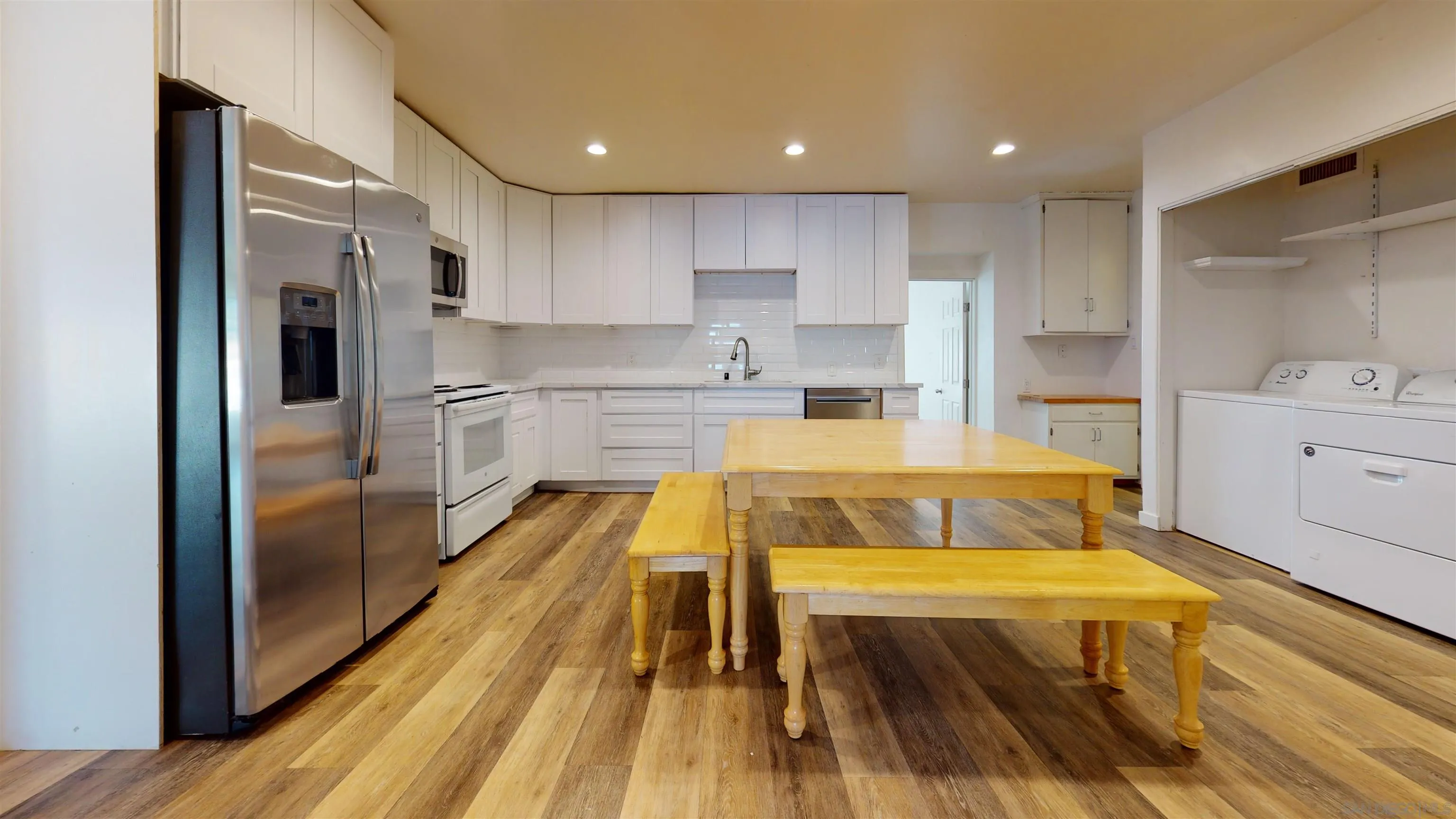 5555 Mary Ln Drive San Diego, CA 92115 - Photo 9 of 39 a kitchen with kitchen island white cabinets and stainless steel appliances