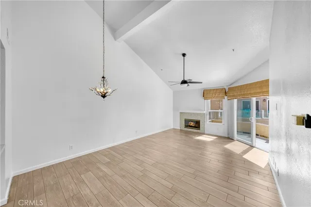 a view of a livingroom with a fireplace wooden floor and chandelier