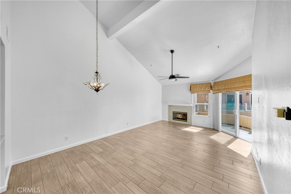 2000 Pacific Coast Highway, Unit 309 Huntington Beach, CA 92648 - Photo 14 of 32 a view of a livingroom with a fireplace wooden floor and staircase