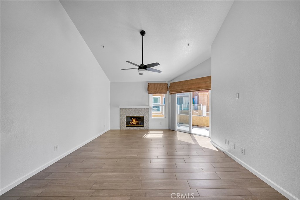 2000 Pacific Coast Highway, Unit 309 Huntington Beach, CA 92648 - Photo 15 of 32 a view of an empty room with wooden floor fireplace and a window