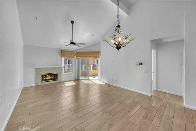 a view of a hallway with wooden floor and a bathroom