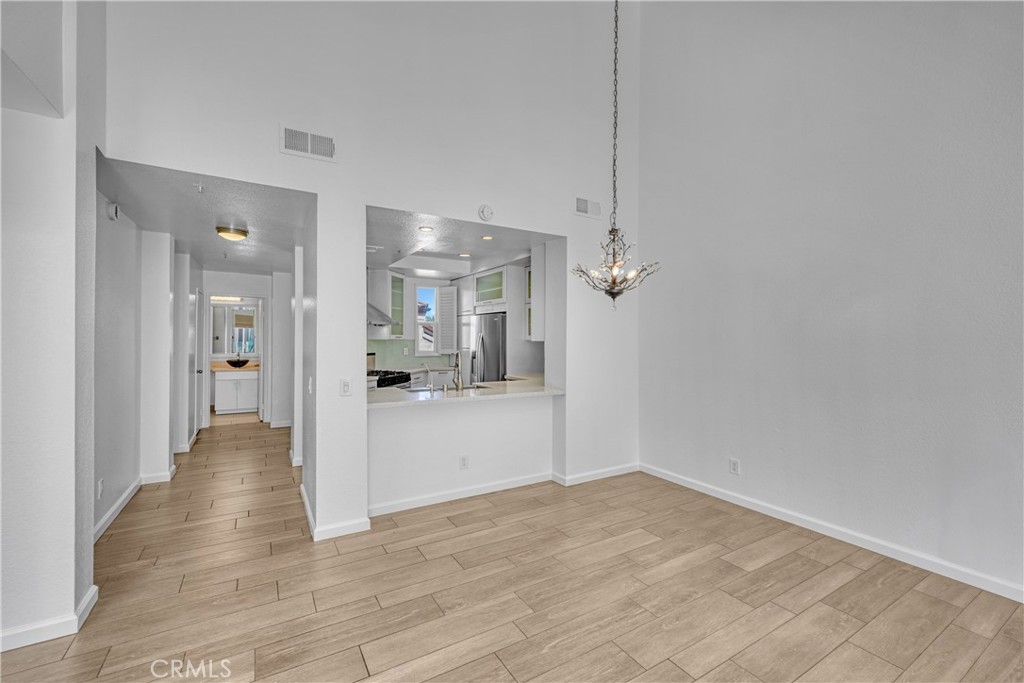 2000 Pacific Coast Highway, Unit 309 Huntington Beach, CA 92648 - Photo 18 of 32 a view of a hallway with wooden floor and a bathroom