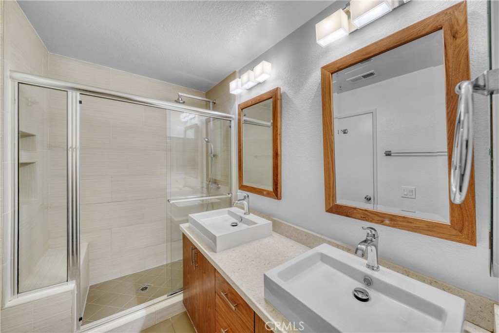 2000 Pacific Coast Highway, Unit 309 Huntington Beach, CA 92648 - Photo 24 of 32 a bathroom with a sink and a mirror
