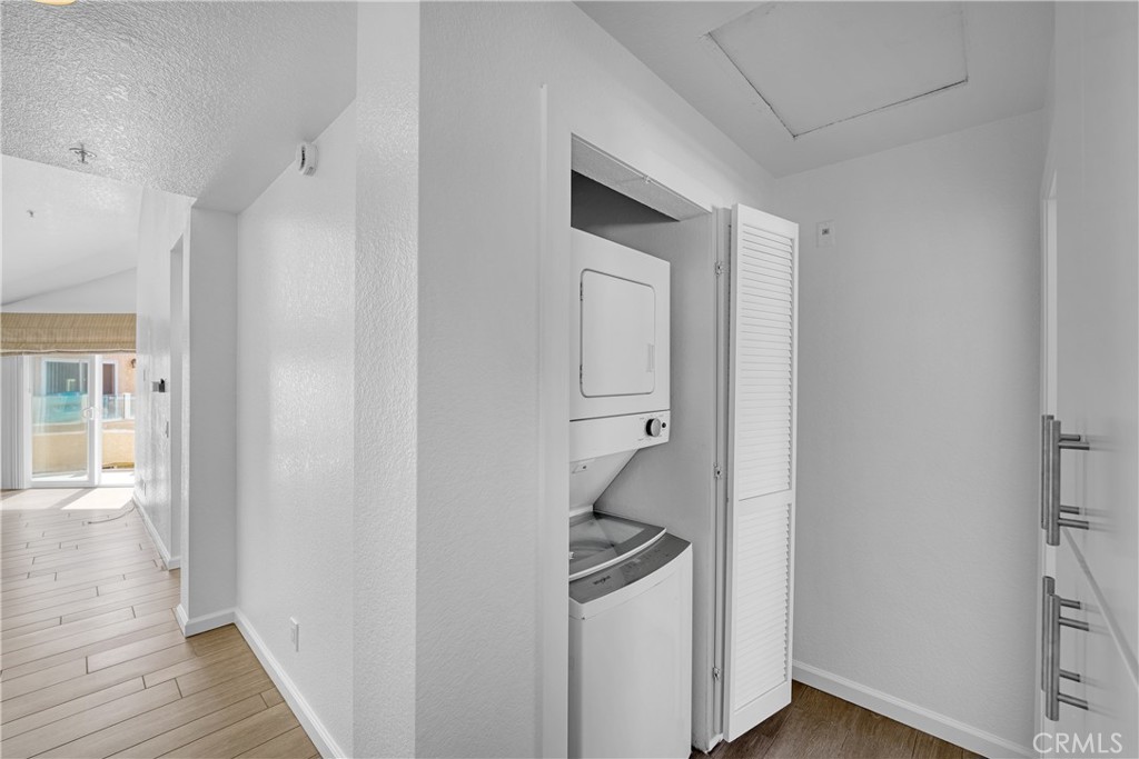 2000 Pacific Coast Highway, Unit 309 Huntington Beach, CA 92648 - Photo 28 of 32 a room with wooden floor and white walls