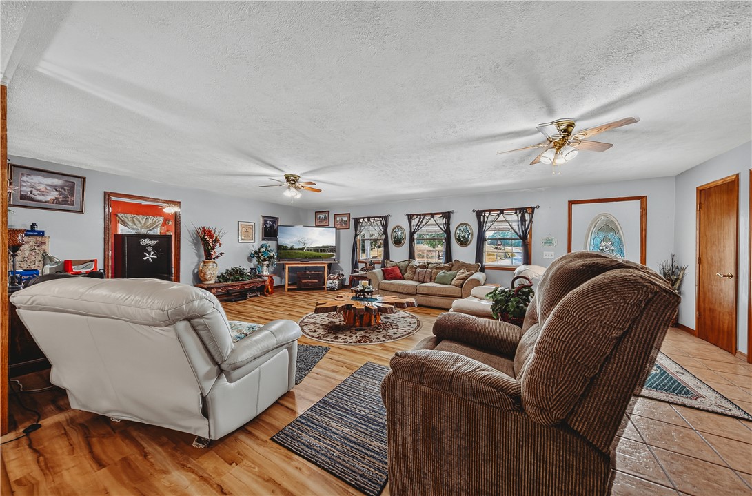 21587 West Hickory Flat Road Springdale, AR 72764 - Photo 15 of 45 Another view of the generously sized living room with multiple windows, ceiling fans, and plenty of room for gathering.