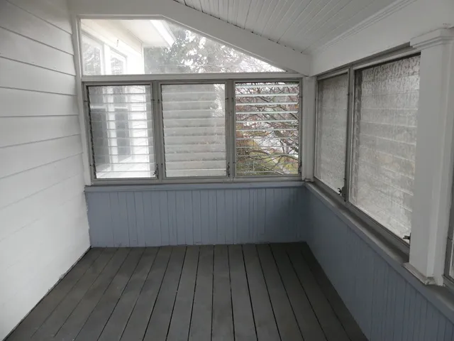 a view of a room with wooden floor and a window
