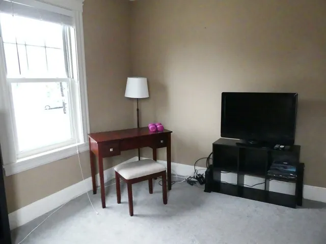 a living room with furniture a window and a flat screen tv
