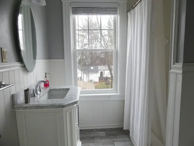 a bathroom with a sink a mirror and a window